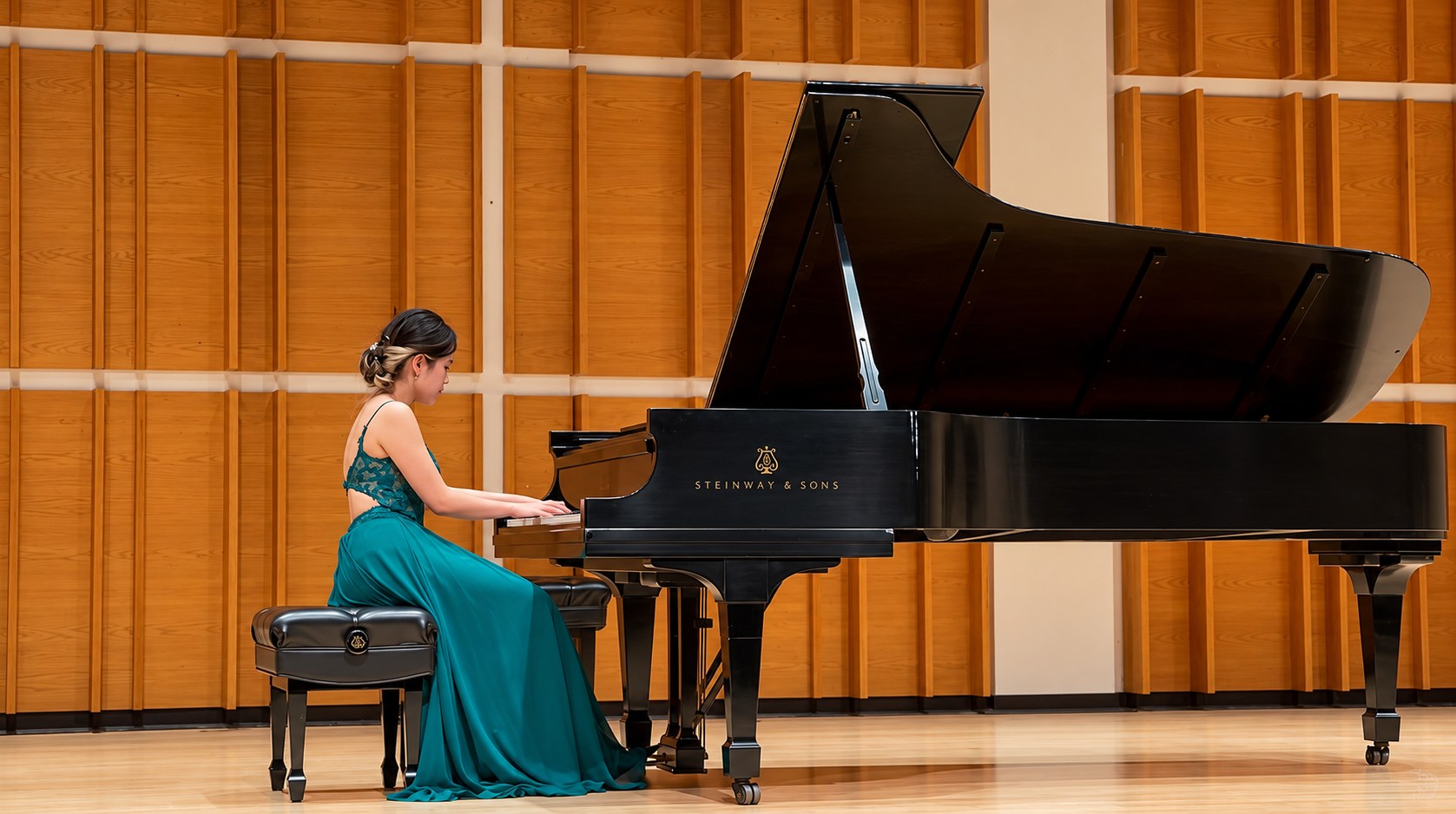 Mary in an emerald gown at a grand piano